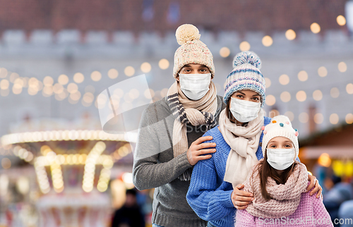 Image of family in medical masks at christmas market