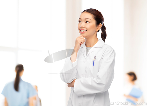 Image of thinking asian female doctor at hospital