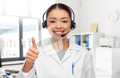 Image of smiling asian female doctor in headset at hospital