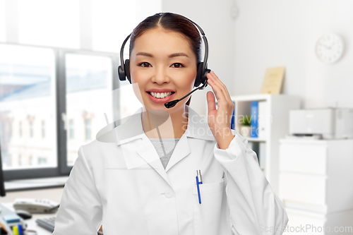 Image of smiling asian female doctor in headset at hospital