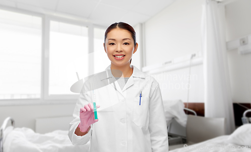 Image of asian female doctor with syringe at hospital