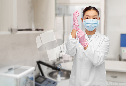Image of asian female doctor in medical mask and gloves