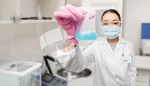 Image of asian doctor or scientist in mask with flask