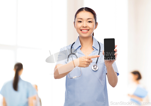 Image of asian female nurse with smartphone at hospital