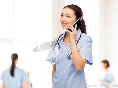 Image of asian nurse calling on smartphone at hospital