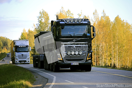 Image of Heavy Trucks on Road at Autumn Sunset