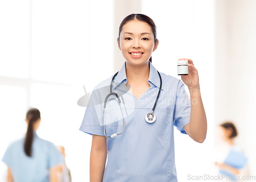 Image of happy asian female nurse with medicine at hospital