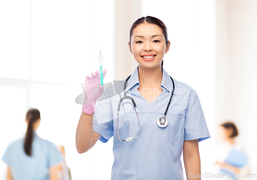 Image of happy asian female nurse with medicine and syringe