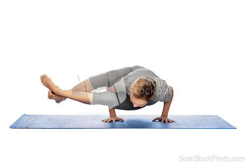 Image of woman making yoga in handstand on mat