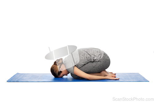 Image of woman doing yoga child pose on mat