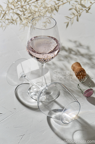 Image of wine glasses dropping shadows on white surface