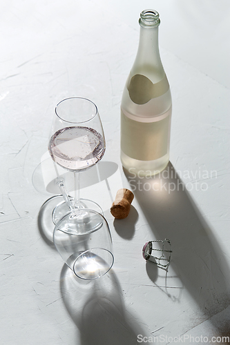 Image of wine glasses and champagne bottle dropping shadows