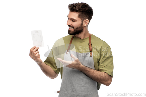 Image of happy smiling barman in apron with bill