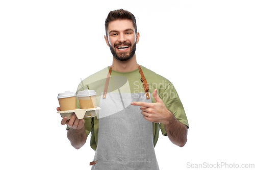 Image of happy smiling barman in apron with takeaway coffee