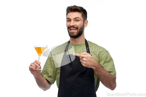 Image of happy barman in apron with glass of cocktail