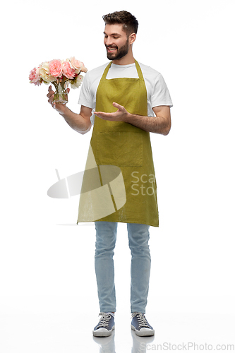 Image of happy smiling male gardener with flowers in vase