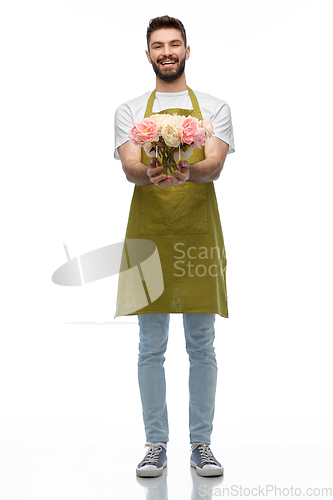 Image of happy smiling male gardener with flowers in vase