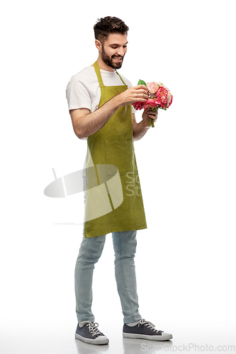 Image of smiling male gardener with bunch of peony flowers