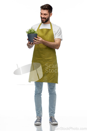 Image of happy smiling male gardener with flower in pot