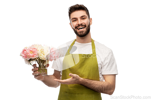 Image of smiling male gardener with bunch of peony flowers