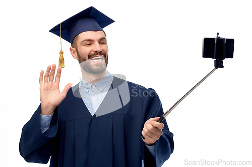 Image of male graduate student with smartphone takes selfie