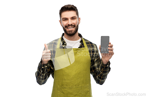 Image of happy male farmer with smartphone shows thumbs up
