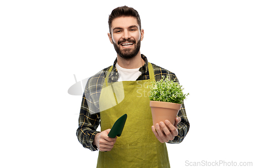 Image of happy gardener or farmer with trowel and flower