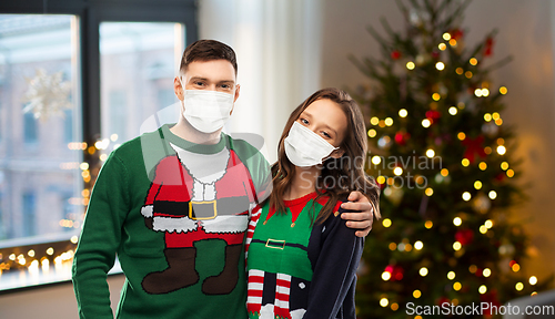 Image of couple in masks and sweaters on christmas
