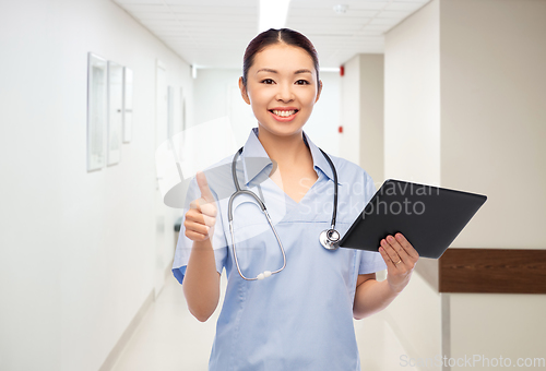 Image of nurse with tablet pc shows thumbs up at hospital