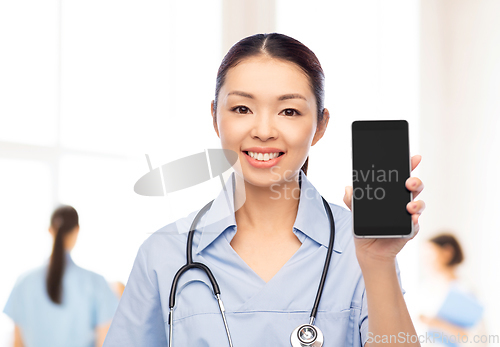 Image of asian female nurse with smartphone at hospital