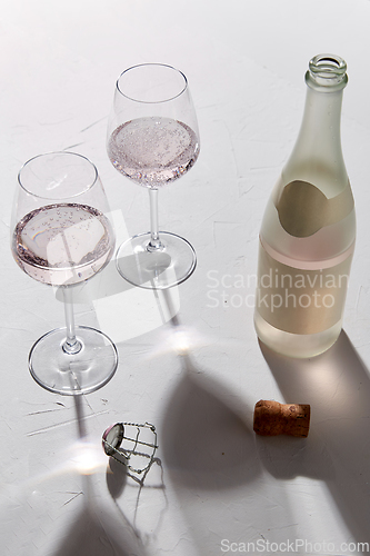 Image of wine glasses and champagne bottle dropping shadows