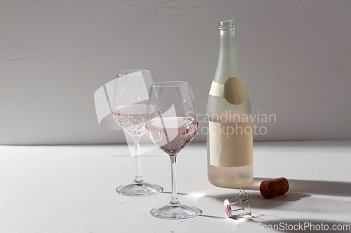 Image of wine glasses and champagne bottle dropping shadows