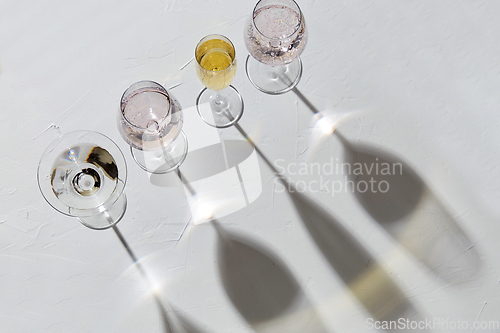 Image of wine glasses dropping shadows on white surface