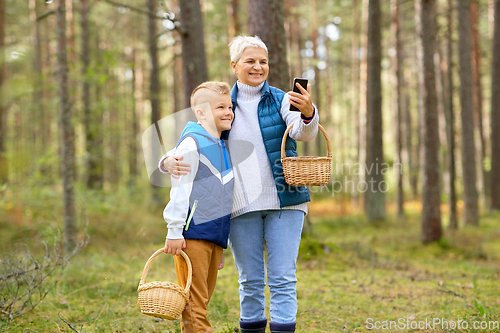 Image of grandmother and grandson with baskets take selfie