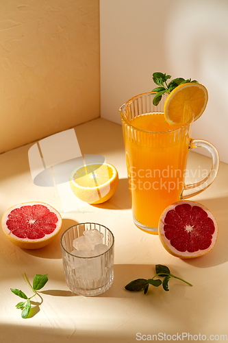 Image of orange juice, grapefruit and ice in glass on table