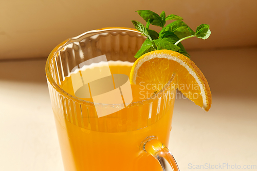 Image of close up of jug with orange juice and peppermint