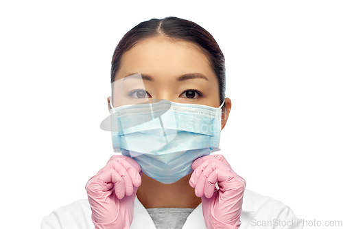 Image of asian female doctor in medical mask and gloves