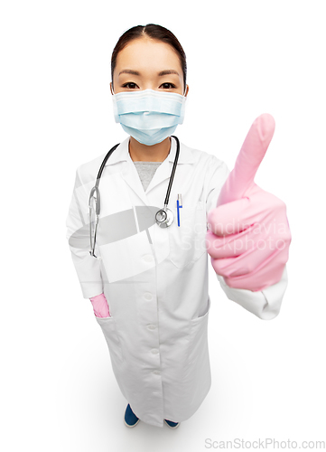 Image of asian female doctor in mask showing thumbs up