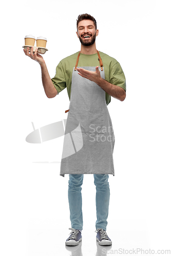 Image of happy smiling barman in apron with takeaway coffee