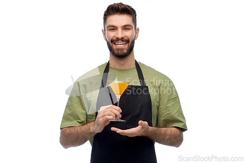 Image of happy barman in apron with glass of cocktail