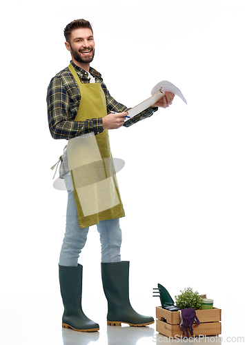 Image of happy gardener with clipboard with garden tools