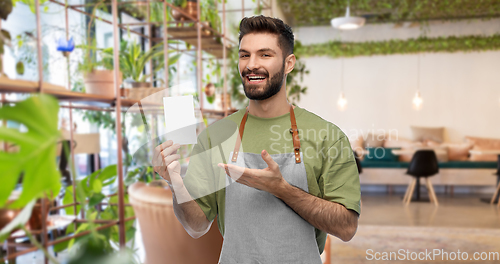 Image of smiling barman in apron with bill at restaurant