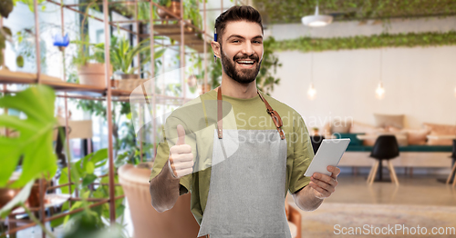 Image of waiter with notepad shows thumbs up at restaurant