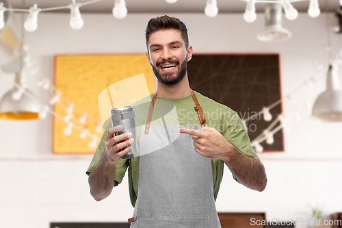 Image of happy waiter with tumbler or takeaway thermo cup