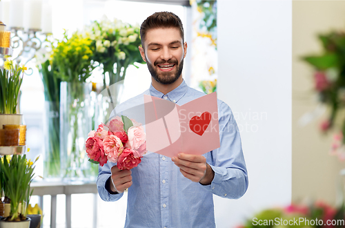 Image of happy man with valentine's day card at flower shop