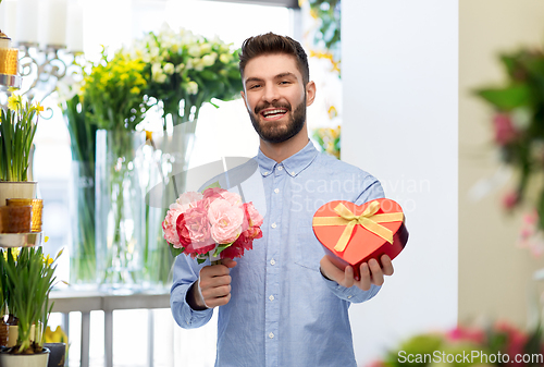 Image of happy man with valentine's day gift at flower shop