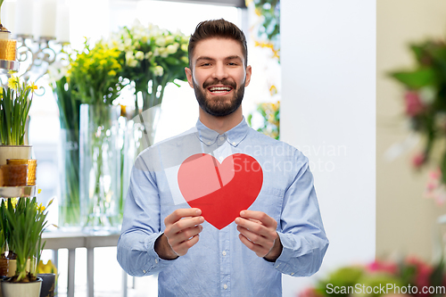 Image of happy smiling man with red heart at flower shop