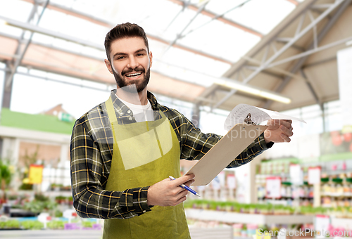 Image of male gardener with clipboard at flower shop