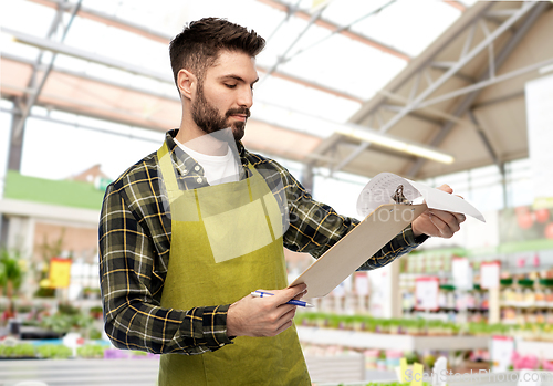 Image of male gardener with clipboard at flower shop