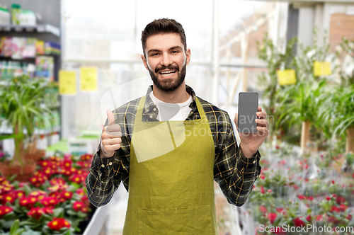 Image of seller with phone shows thumbs up at flower shop